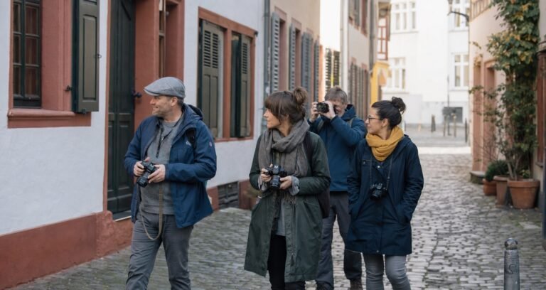 Vier Fotografen mit Kameras bei einem Fotowalk in einer Altstadtgasse