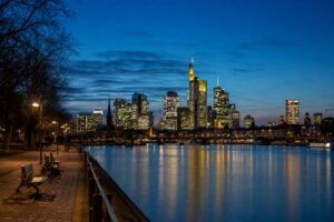 Frankfurter Skyline am Main während der blauen Stunde mit beleuchteten Hochhäusern